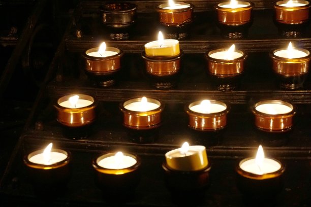 罗马天主教堂里的小燃烧器被信徒们点燃，特写形成背景。图片下载