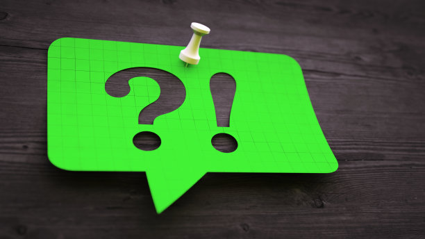 一个绿色的气泡便条，用一个问号和感叹号固定在深色的木头表面上。图片下载