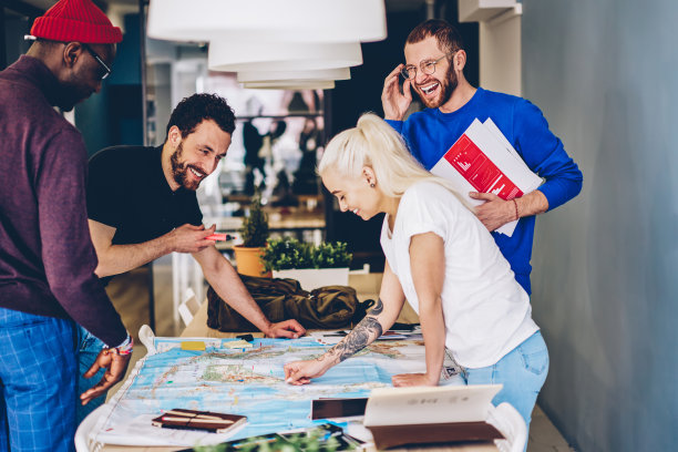 在学院的头脑风暴会议上，一群来自不同文化背景的学生在地图上寻找正确的路线并做出标记。积极小组的年轻人讨论地理计划图片下载