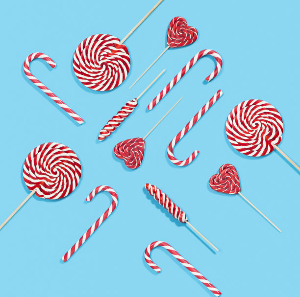 圣诞红色糖果手杖和棒棒糖图案在蓝色的背景。圣诞快乐，糖果和新年快乐的概念图片下载