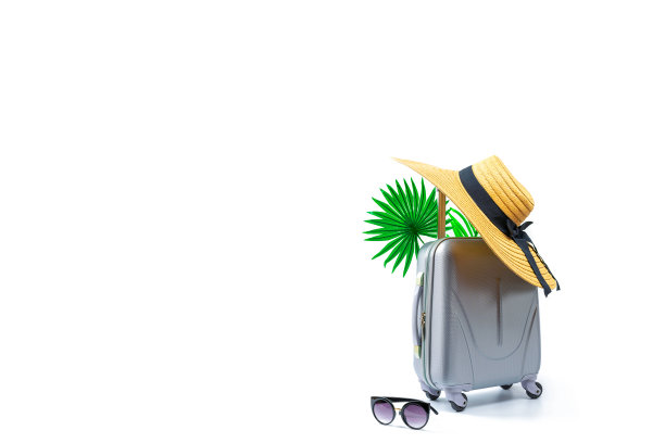 夏天概念背景。旅行配件与手提箱，草帽，棕榈叶在最小的旅行度假概念孤立上白色。复制空间，暑假和商务旅行的概念。图片下载
