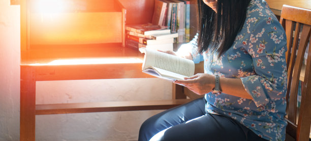 在大学或学校的图书馆看书或文学作品的妇女。知识教育的概念。图片下载