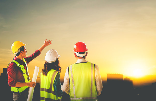 三个土木工程师团队正在研究一个金色日落的沙漠夏季城市的发展。图片下载