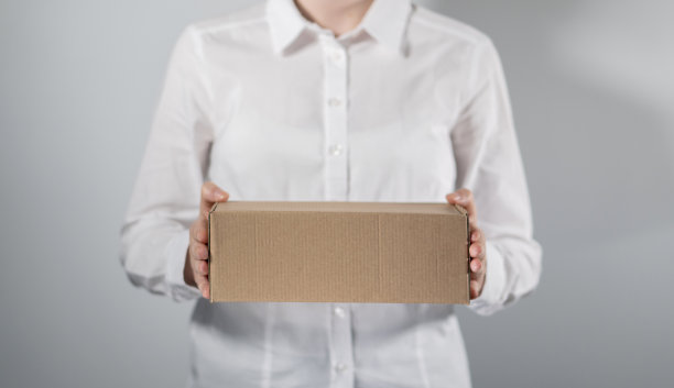 拿着纸板箱的快递女/拿着纸板箱的女商人。图片下载