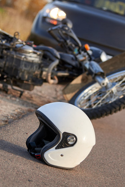 照片上的汽车，头盔和摩托车在道路上，道路事故的概念。图片下载