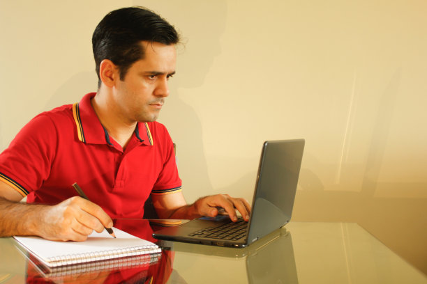 一个人在用他的笔记本做笔记图片下载