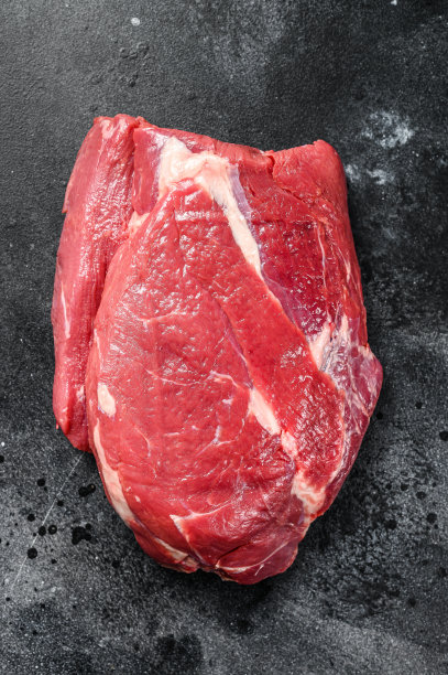 切成圆形的生牛肉。黑色背景。俯视图图片下载