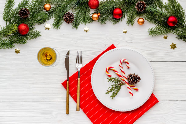 俯视图的圣诞餐桌位置设置与空盘子和节日装饰图片下载