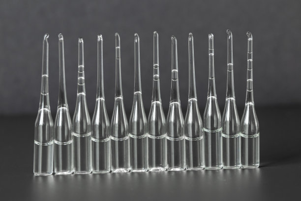 许多医用安瓿在深灰色的背景上排成一行。特写镜头。卫生保健的概念。图片下载