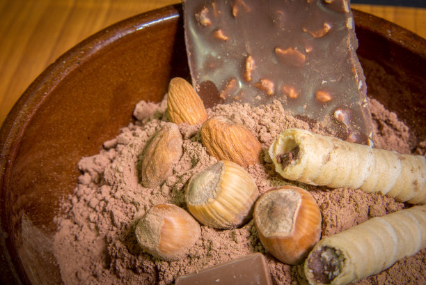 苦味和牛奶巧克力，坚果和其他糖果在木桌库存照片图片下载