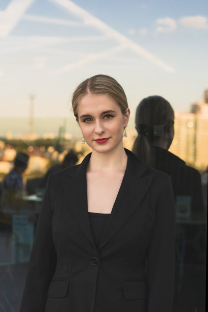 一个穿着黑衣服的金发美女的肖像，以城市为背景图片下载