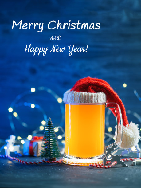 圣诞快乐，节日祝酒。装饰好的圣诞桌子上放着一大杯戴着圣诞帽的季节性啤酒图片下载