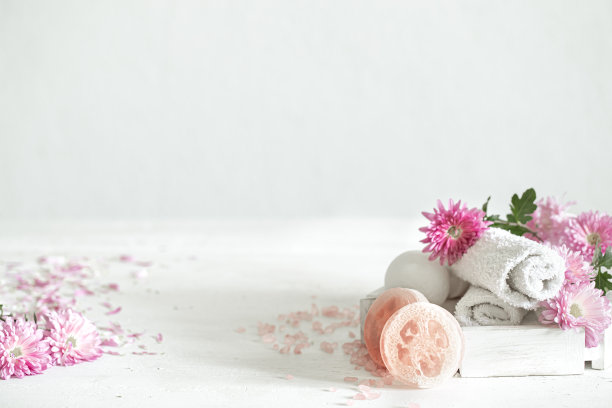 水疗组合与身体护理产品和鲜花在一个轻的背景复制空间。图片下载