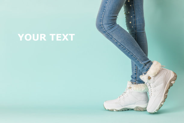 穿着绝缘运动鞋和紧身牛仔裤的女孩的腿。图片下载