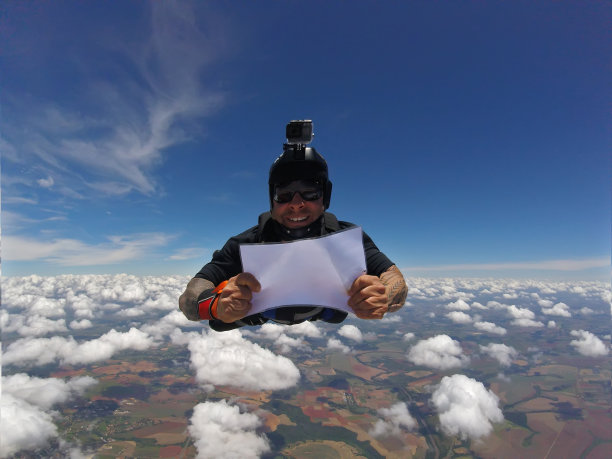 微笑的伞兵拿着一块空白板。图片下载