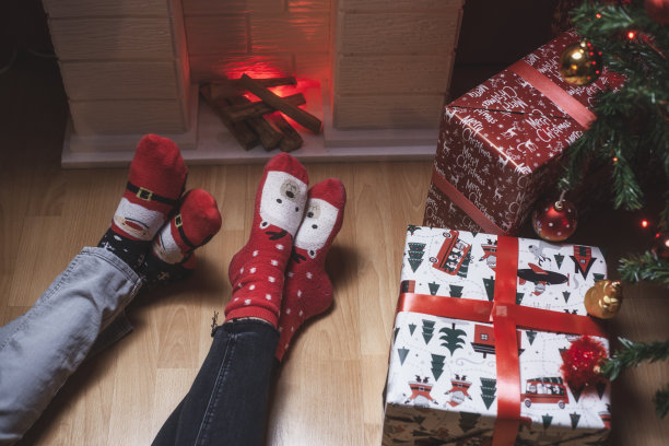 圣诞节前夕在壁炉前的两个人的腿的特写照片图片下载