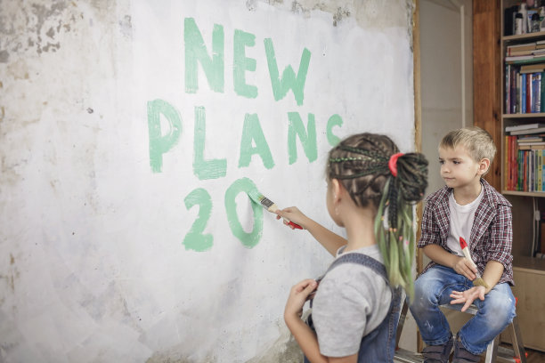 父亲和孩子们一起修补房间，拆下墙纸，计划着在墙上过新年图片下载