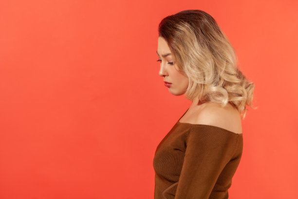 不快乐和疲惫的女人的侧视向下看图片下载