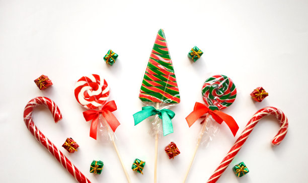 明亮甜美的圣诞棒棒糖在白色的背景图片下载