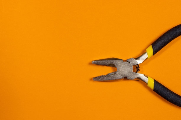 平底是金属在橙色的背景与复制空间文本的地方。工作坊及建材仓库照片。图片下载