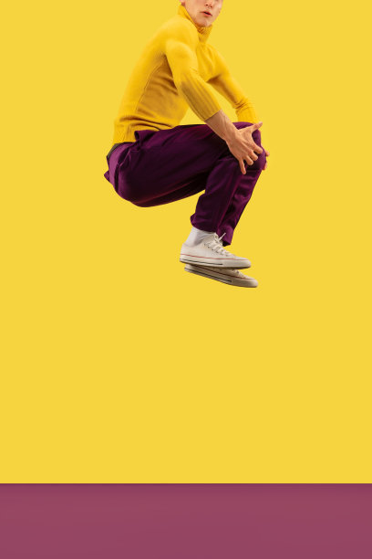 年轻男子在黄色演播室背景上孤立地跳着图片下载
