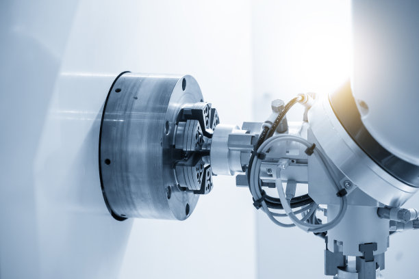 机器人手臂从数控车床上抓住金属部分。图片下载