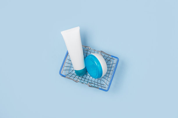 购物筐里放着几瓶白色的化妆品。网上直销。购买消毒、洗衣和护理产品。图片下载