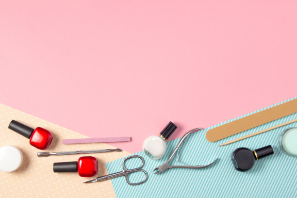 粉色和蓝色背景的美甲工具。指甲锉，剪刀和指甲油俯视图。指甲沙龙，美容沙龙图片下载