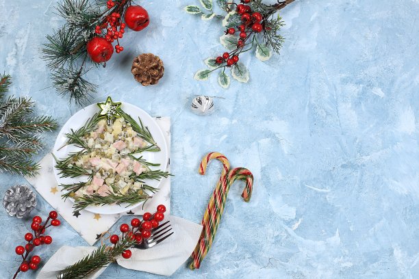圣诞新年菜肴，传统节日的奥利维尔沙拉与冷杉树枝和锥形和装饰在轻桌上，菜肴设计理念，选择性焦点，图片下载