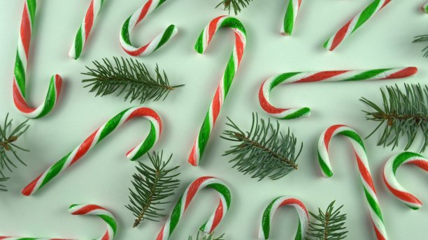 圣诞节当天的餐桌上摆放着各种糖果和白色背景的节日糖果。新年装饰用各种金粉。图片下载