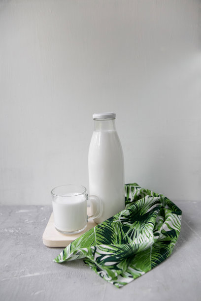 瓶子与牛奶在一个轻的背景，垂直照片图片下载