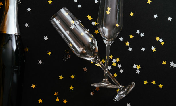 黑色背景上的香槟酒瓶和两个玻璃杯图片下载