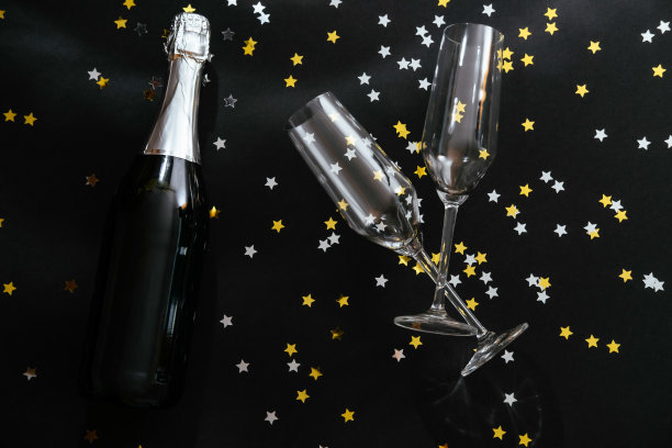 黑色背景上的香槟酒瓶和两个玻璃杯图片下载