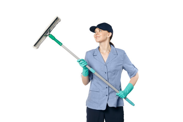 黑发女孩戴着棒球帽，穿着清洁工制服，微笑着用特制的拖把擦着窗户图片下载
