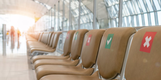 在新冠肺炎和冠状病毒大流行无人的情况下，在机场或公交终点站的空椅子上设置座位分配和座位距离限制警告标志，以确保旅行安全图片下载