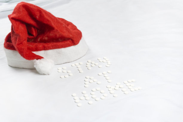 留在家里的字母由圆形的白色药丸。白色背景图片下载