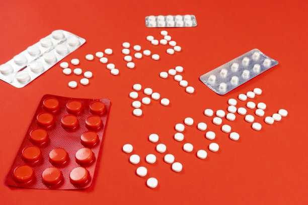 呆在家里，红色背景上的圆形白色药丸。包药图片下载