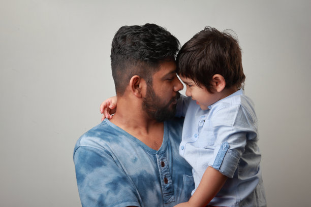 年轻的父亲抱着他顽皮的儿子图片下载