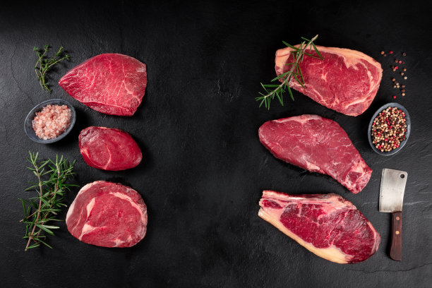 不同部位的肉，在黑色背景下从顶部拍摄，并配上佐料图片下载