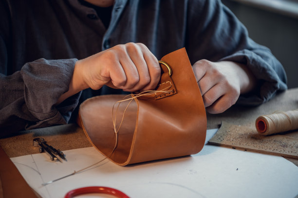 一个年轻的手工艺人在鞋厂创造专属皮鞋的工作流程素材图片