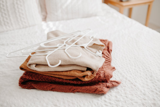 一堆暖和的毛衣挂在衣架上，准备过冬和秋天。图片下载