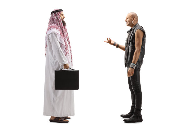 一个阿拉伯商人在一个传统的thobe站着和一个朋克摇滚乐手交谈的完整长度的侧面照片图片下载
