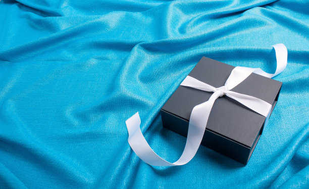 灰色盒子里的礼物，用白色缎带系着。图片下载