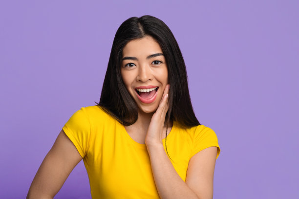 震惊亚洲女性情绪反应惊讶，触摸脸与兴奋图片下载