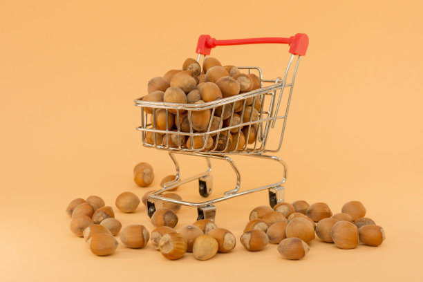 从超市来的小推车里装满了坚果。水平照片，特写，米色背景。概念-自己购买或通过互联网，将任何商品送货上门。图片下载