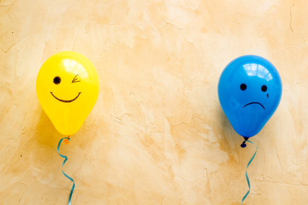 情感的概念。快乐和沮丧的脸在气球上，俯视图片下载
