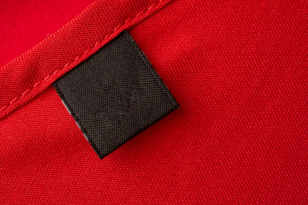 空白黑色洗衣护理衣服标签上红色织物纹理背景图片下载