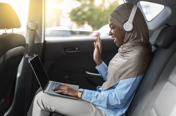 戴着头巾的黑人伊斯兰女士正在用车上的笔记本电脑进行视频通话图片下载