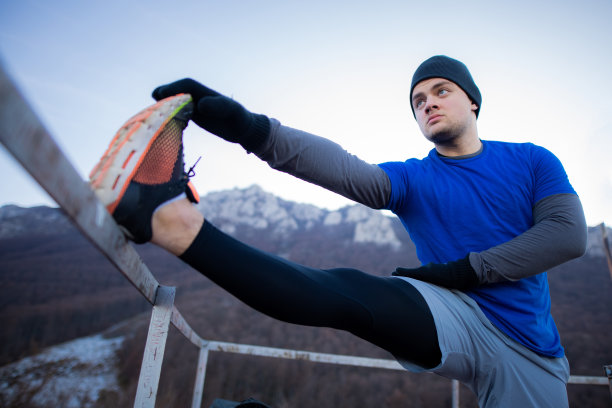 男人们在户外冬季训练前伸伸腿图片下载