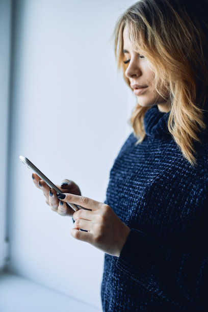 一个女孩的手与一个黑色屏幕的手机的特写。图片下载